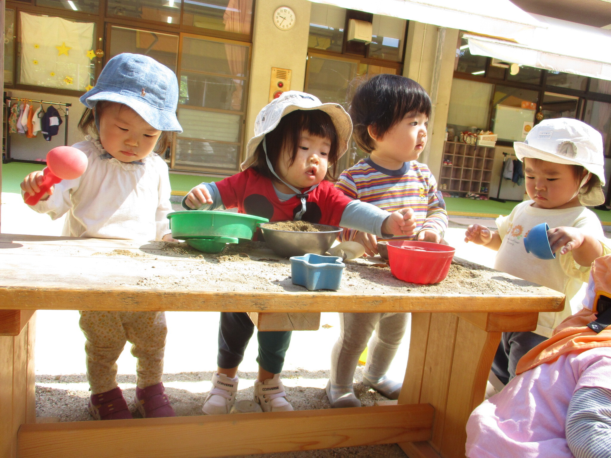  『ごはんですよ』 砂あそびがさかんな1歳児です。みんなでごちそうづくり。今日は何をつくろうかな。いっぱい入れてあげようね。
