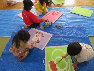 『わたしのいろ』 　子どもたちの前にたくさんの種類の色を登場させると「わあ。きれい」と目を輝かせる子どもたち。「あかがつかいたい」「ぼくは、むらさきがいいな」と自分で好きな色を選んで丁寧に塗っていきます。「あれ、まざったら、こんないろになった」「あかときいろまぜたらオレンジいろになるんや」と画用紙の中で色が混ざり合い、違う色になることに気付きます。「わたしのいろできた」ととても嬉しそうな子どもたちです。