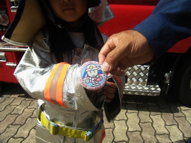 子どもに缶バッジをあげている様子