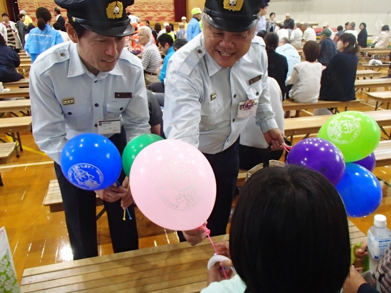 子供たちに風船と缶バッチを手渡します。