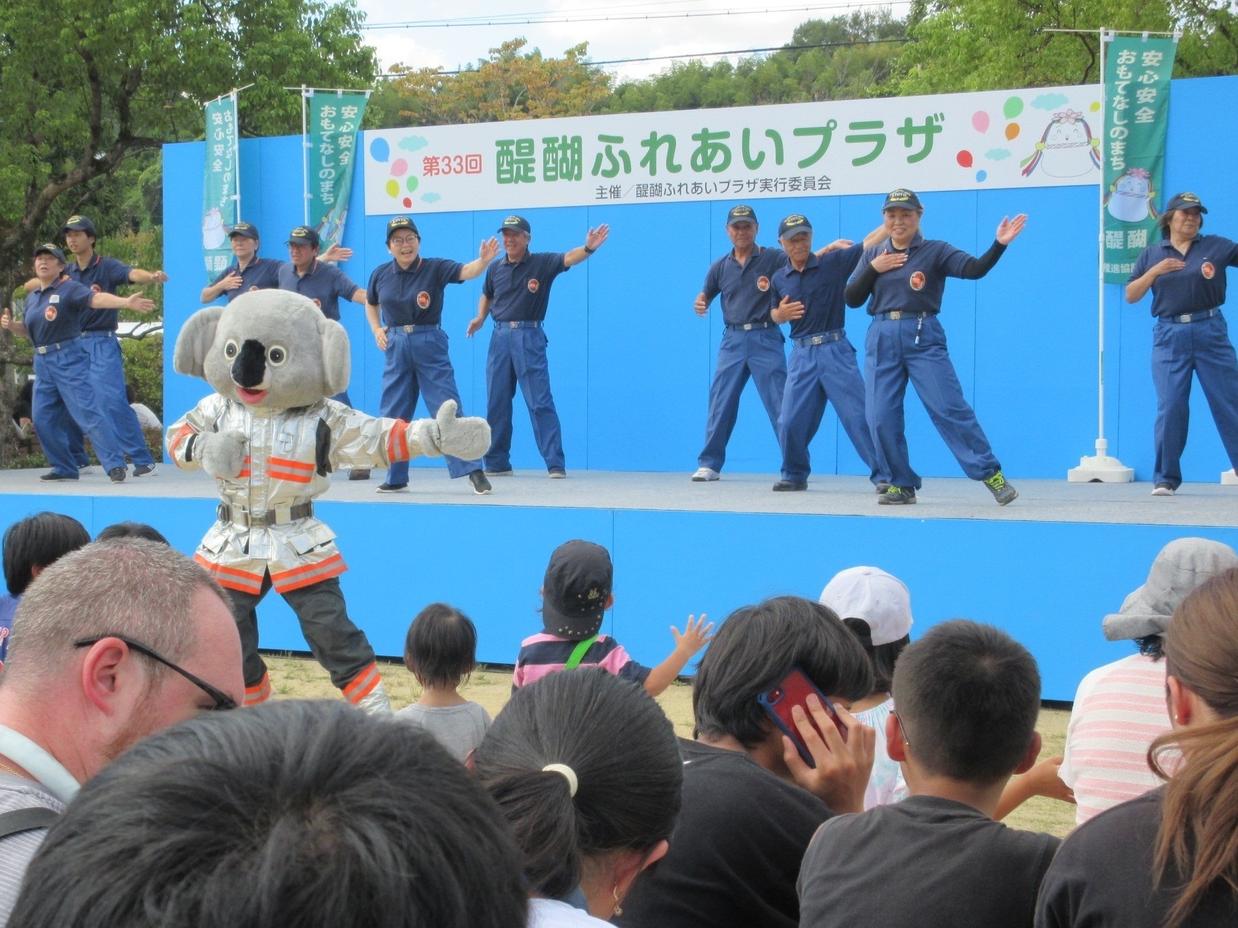 団員とマスコットキャラクターがダンスをしている様子