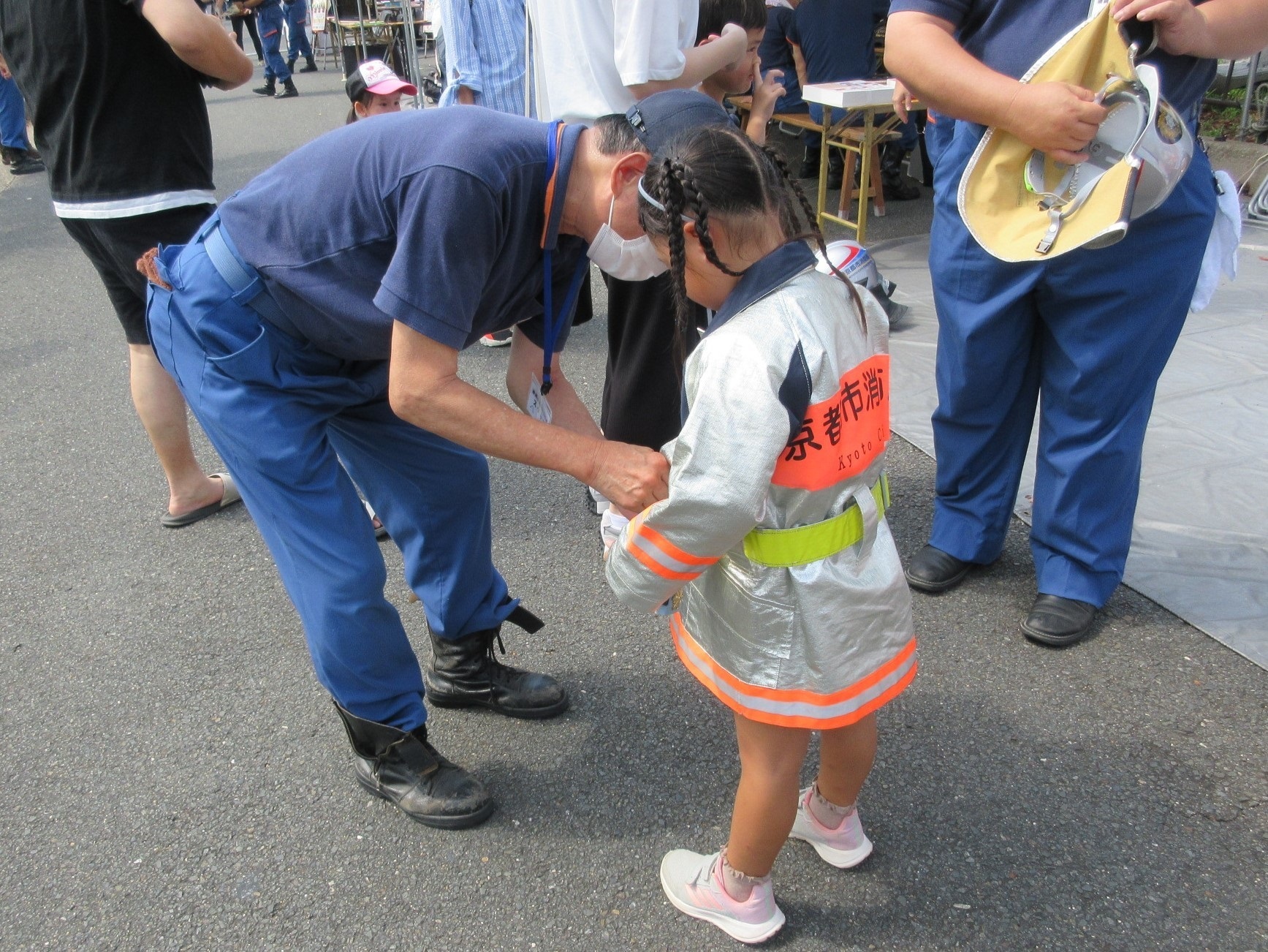 団員が子供に防火服を着せている様子