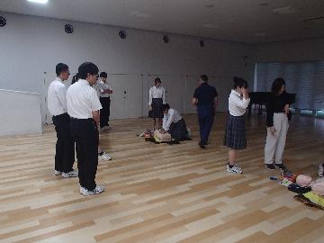 訓練用人形とAEDを使用して実技をする生徒