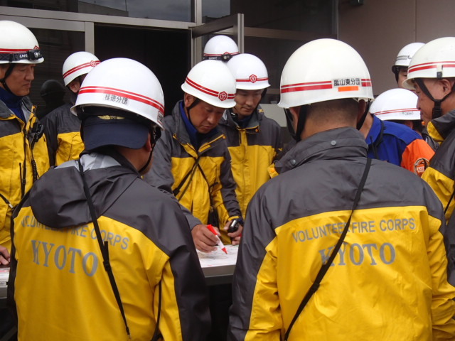 現場指揮本部に現場状況や活動状況を報告する各分団指揮者