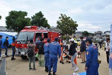 子ども用消防服を着用して消防車に乗車し、記念撮影をしている様子