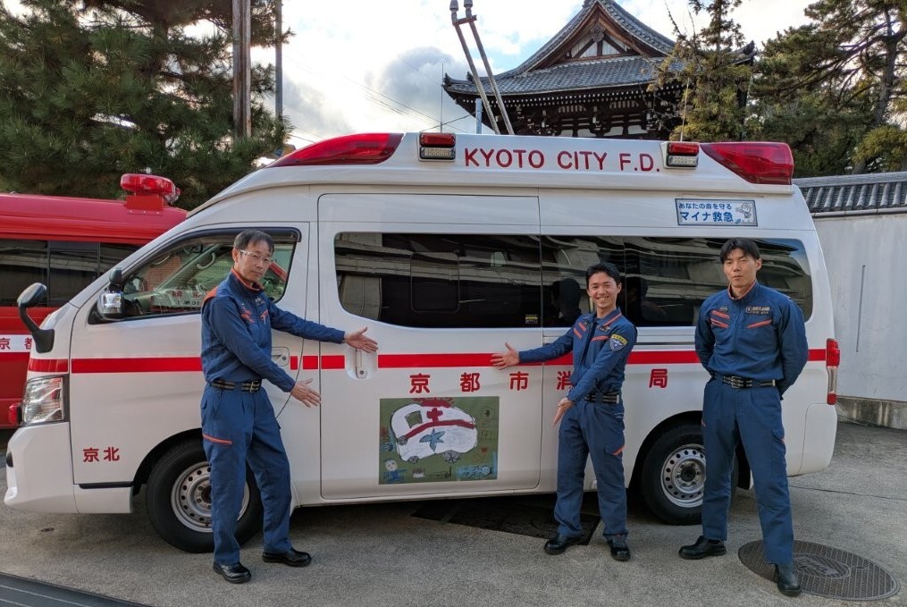 「救急車の絵」を貼った救急車と隊員