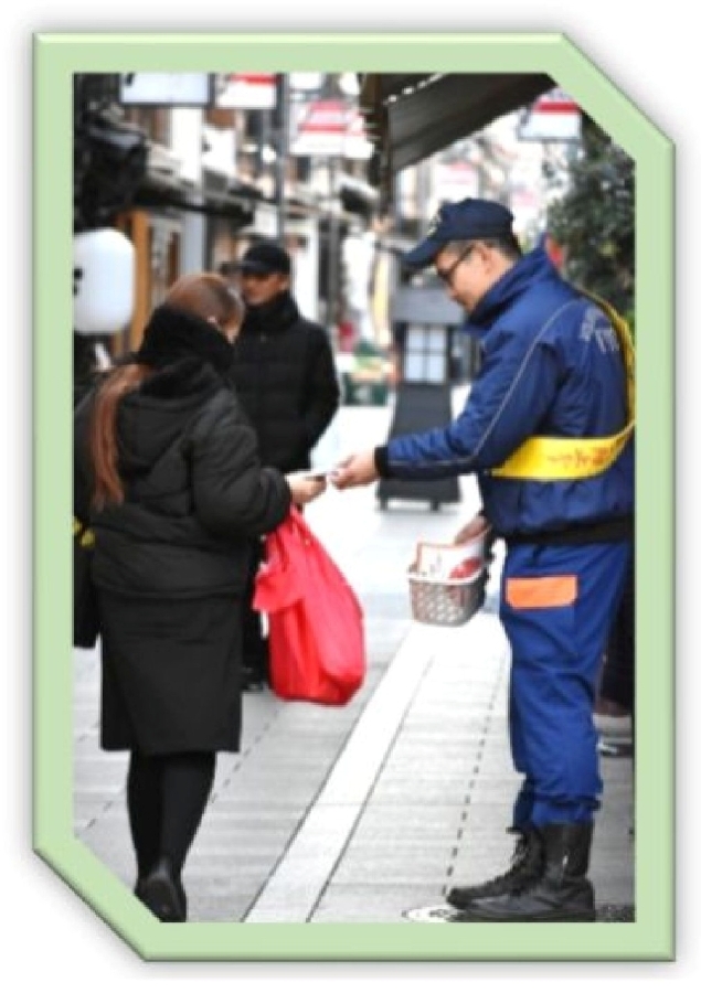 買物客に対し街頭広報を行う伏見消防団員