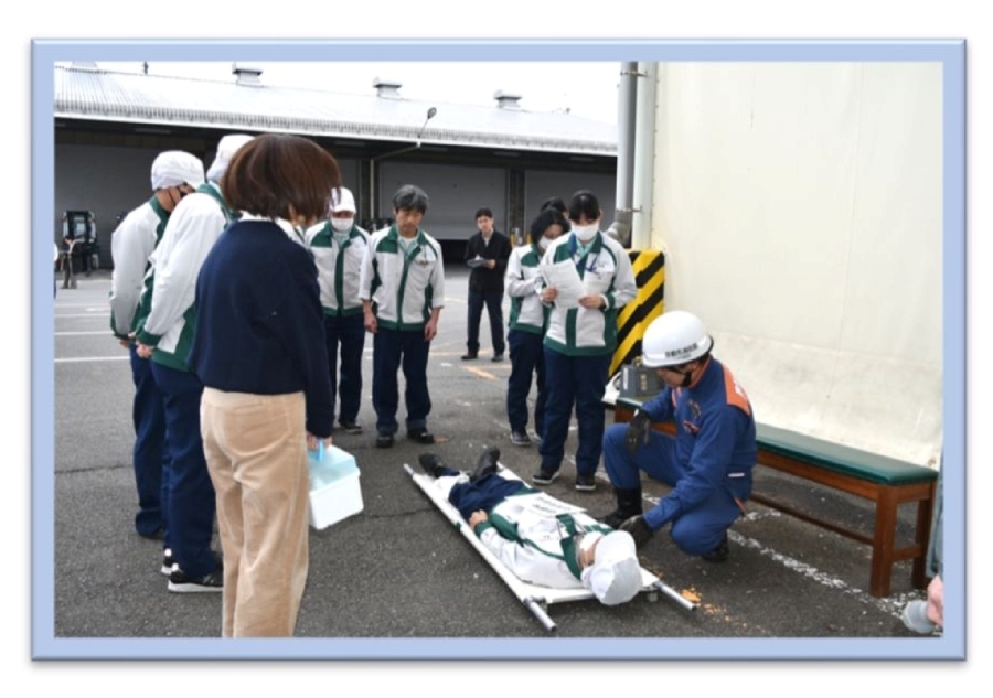 負傷した従業員を救護し、現場に到着した消防職員に引き継ぎを行う自衛消防隊