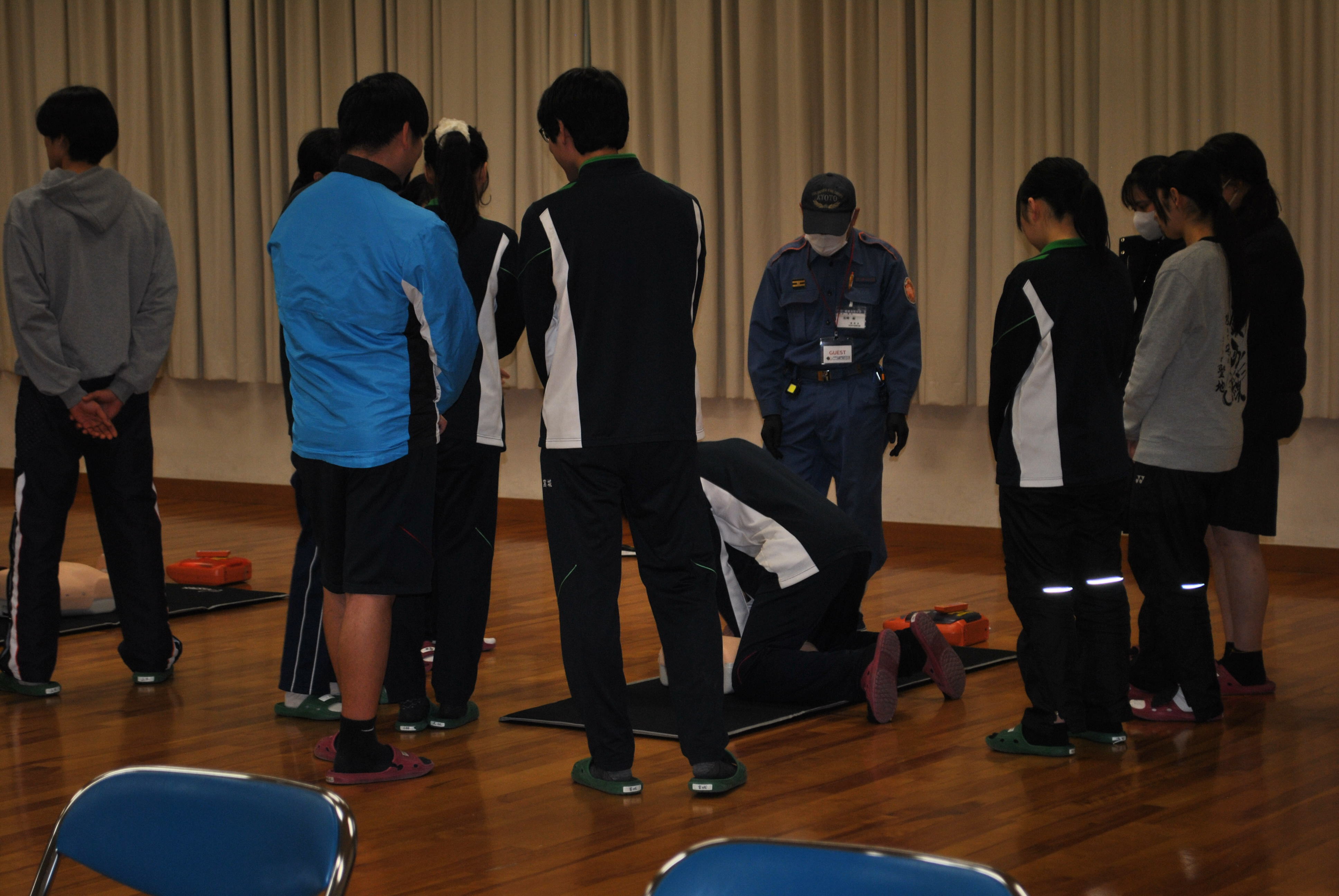 消防団員から胸骨圧迫の指導を受ける嵯峨野高等学校の生徒