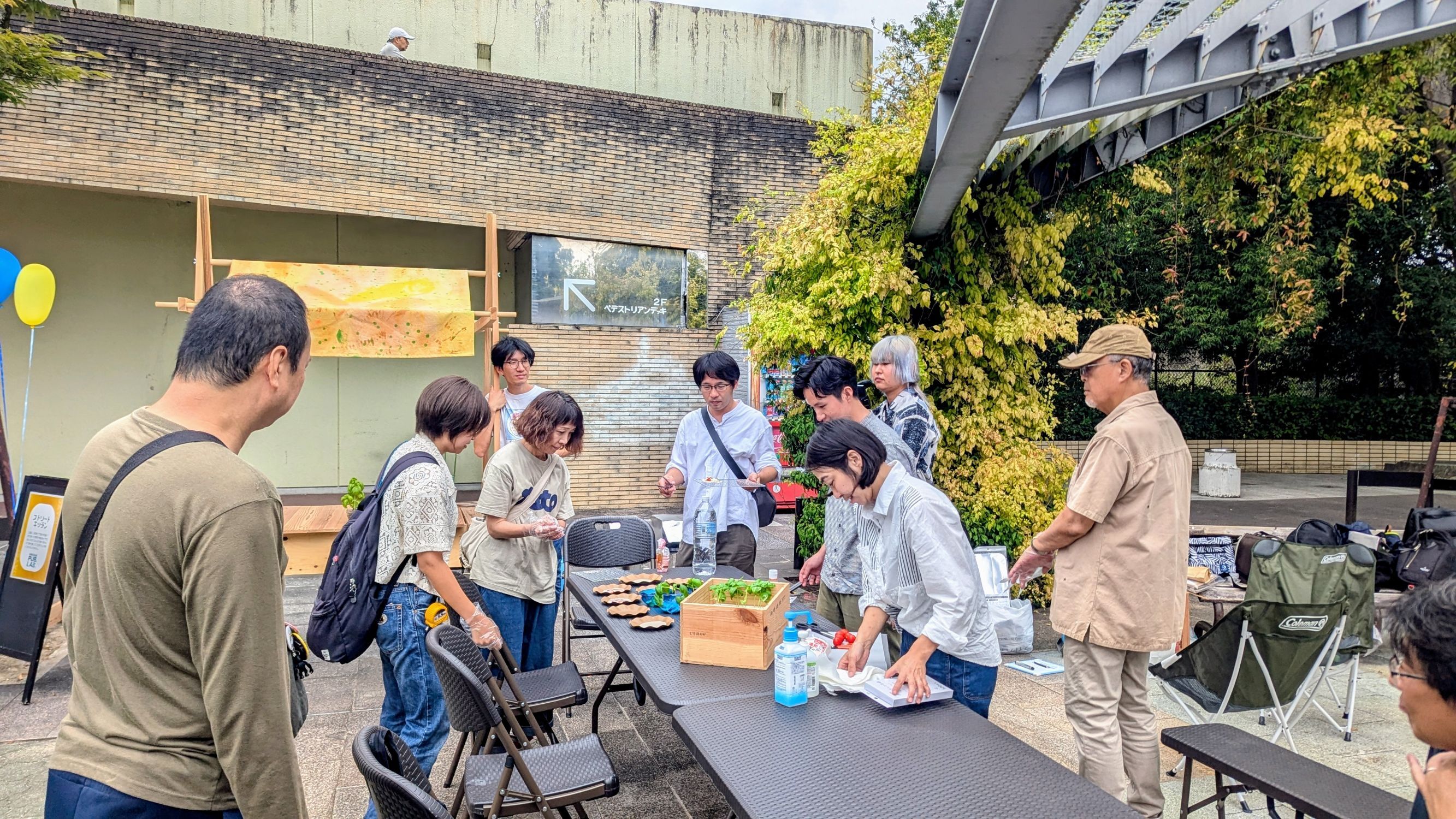 参加者が餃子の皮に具を乗せてピザを作っている様子の写真
