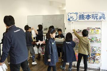 体験後の給料で商品を買う子どもとレジを打つ子ども