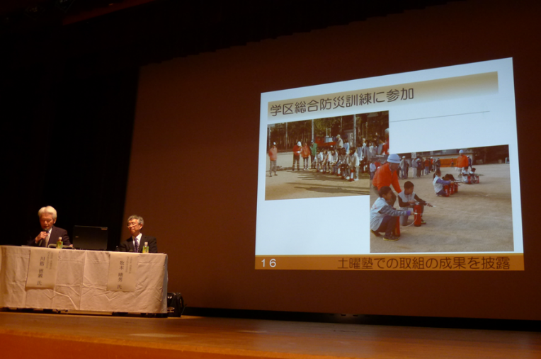 学区総合防災訓練で子ども達が成果を披露，大人も引率するため，結果的に防災訓練の参加率の向上となる。