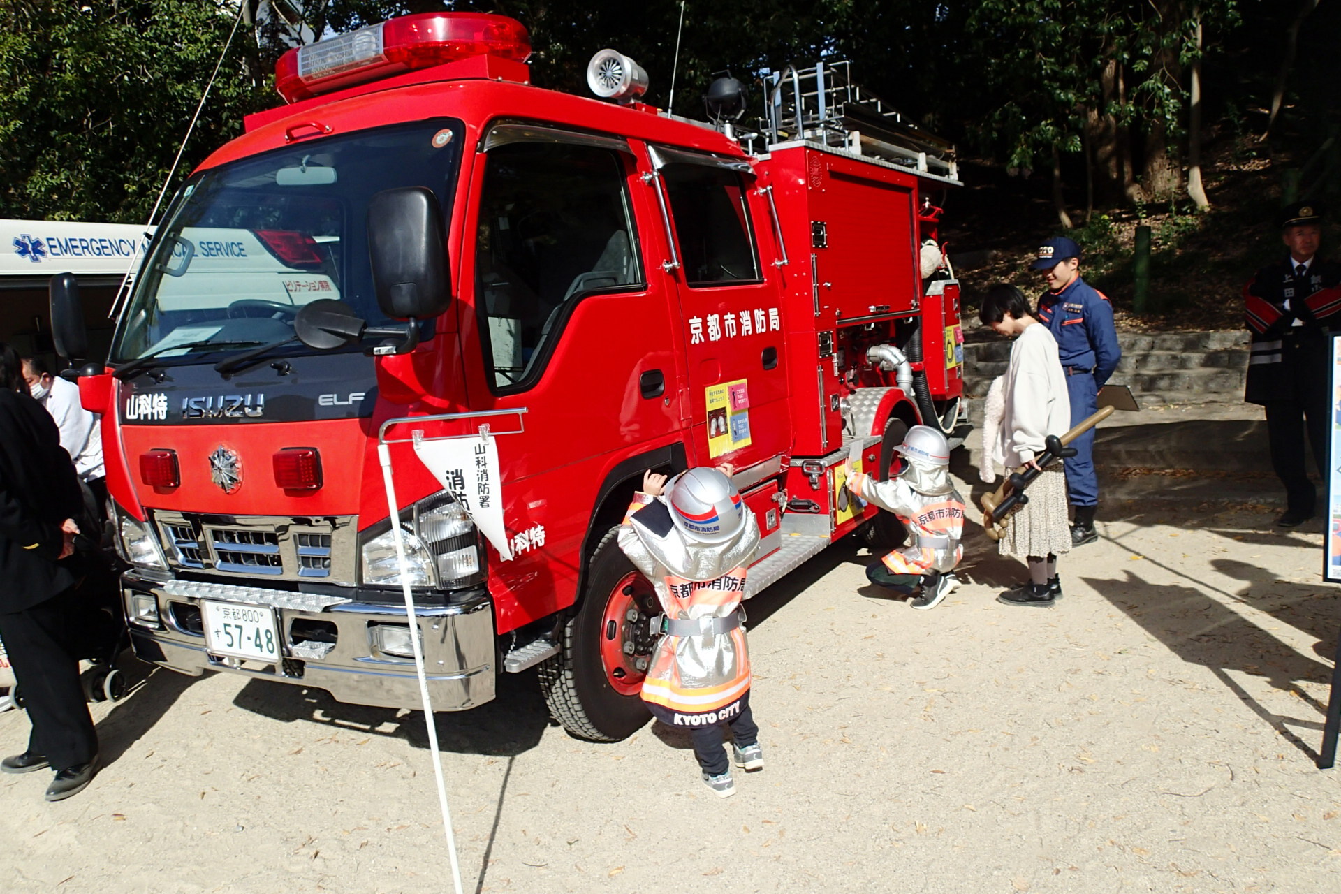 消防車の展示と防火衣を着用する子ども